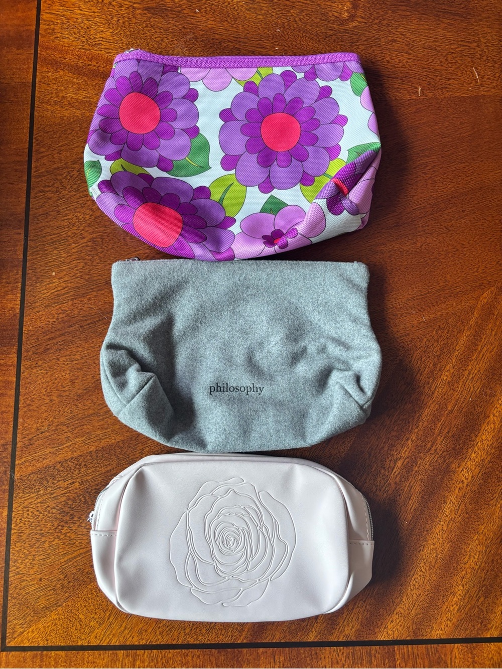 3 makeup bags with purple flowers with red centers and green leaves